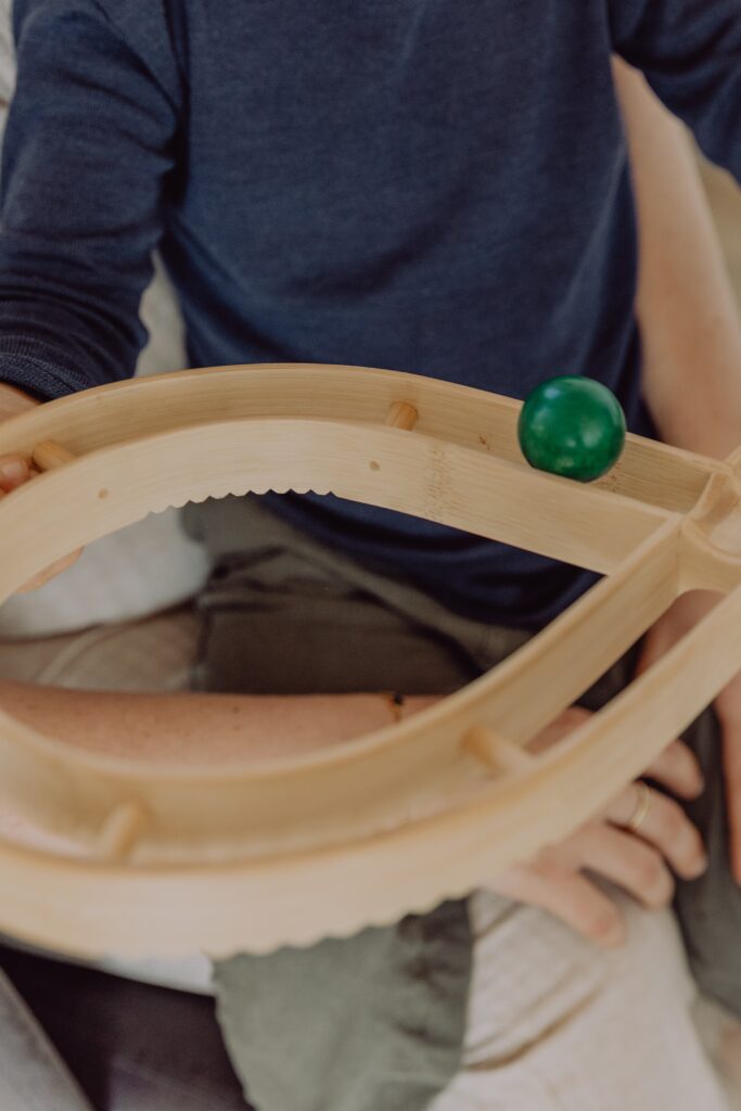 Kinesiologie mit Kind – Brain Gym Übung mit Holzkugel in der Praxis Balance & Wandel